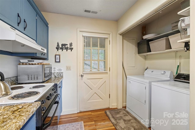 laundry area featuring independent washer and dryer and light hardwood / wood-style floors