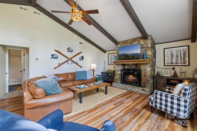 living room with ceiling fan, hardwood / wood-style floors, high vaulted ceiling, a fireplace, and beamed ceiling