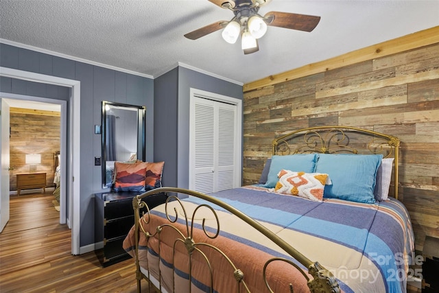 bedroom with dark hardwood / wood-style flooring, ornamental molding, a closet, and wood walls