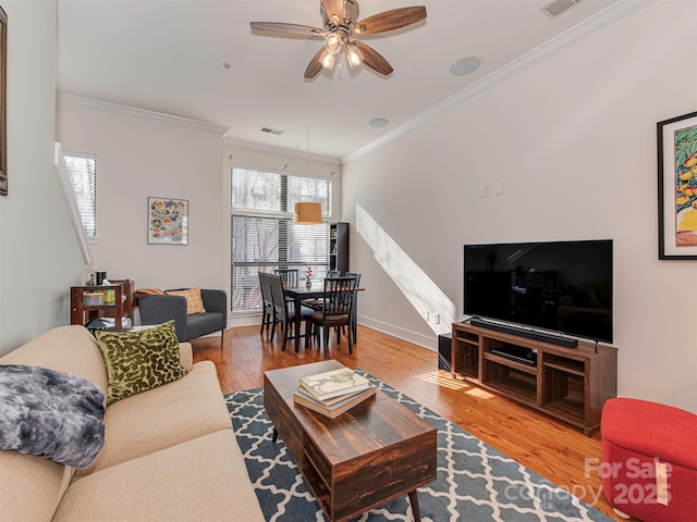 living room featuring crown molding, ceiling fan, and light hardwood / wood-style floors