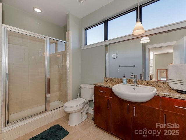 bathroom featuring vanity, tile patterned flooring, a shower with door, and toilet