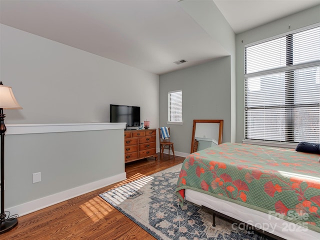 bedroom with hardwood / wood-style flooring and multiple windows