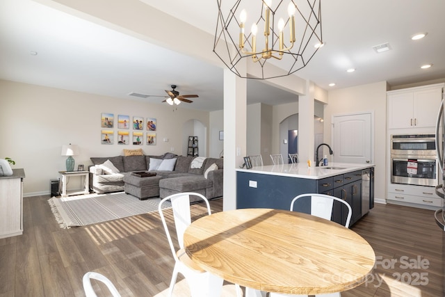 dining space with dark wood-type flooring, ceiling fan, and sink