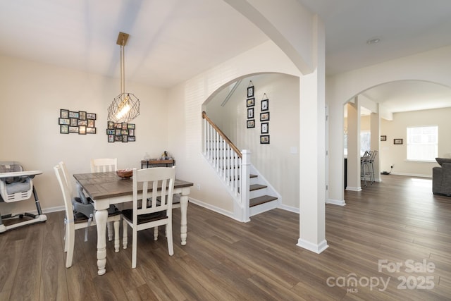 dining room with dark hardwood / wood-style floors and a notable chandelier