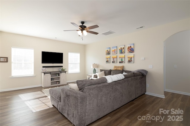 living room featuring dark wood-type flooring and ceiling fan