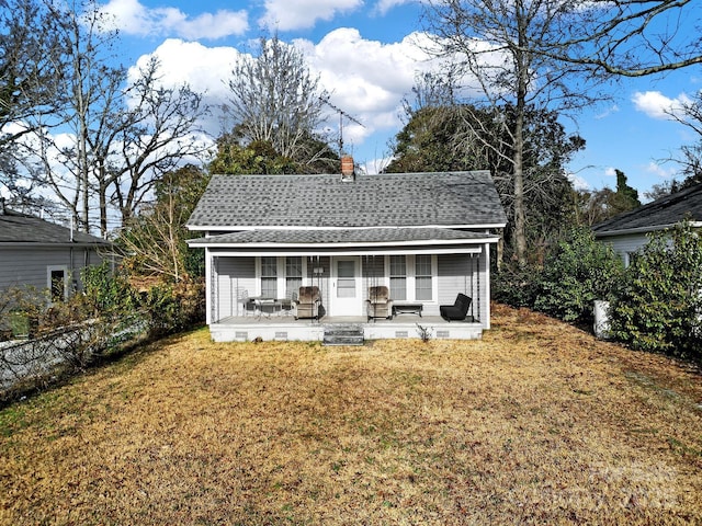 back of property featuring a yard and covered porch