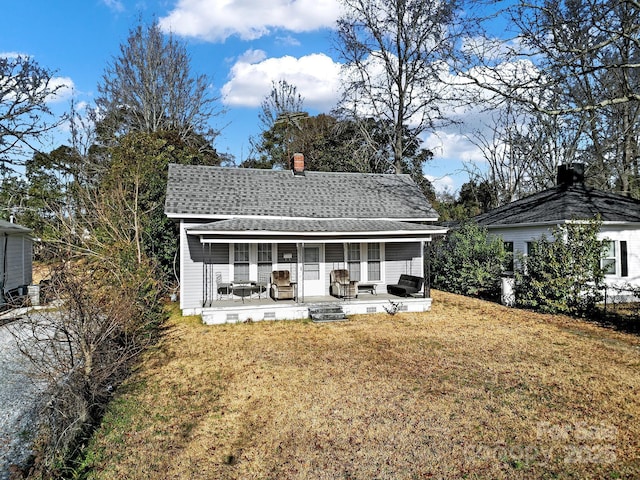 rear view of property with a lawn and a porch