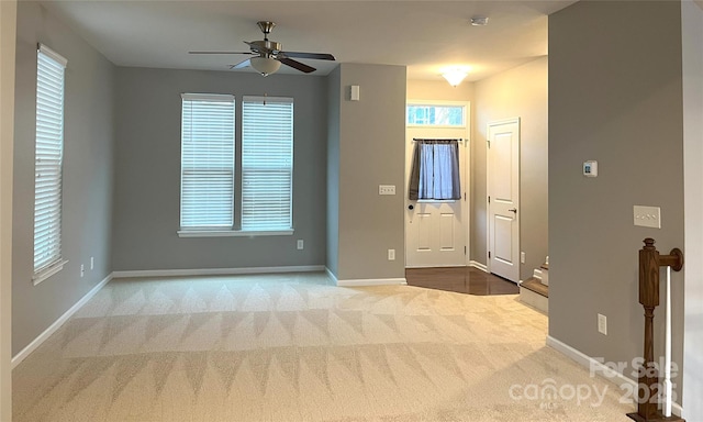 carpeted entrance foyer with ceiling fan