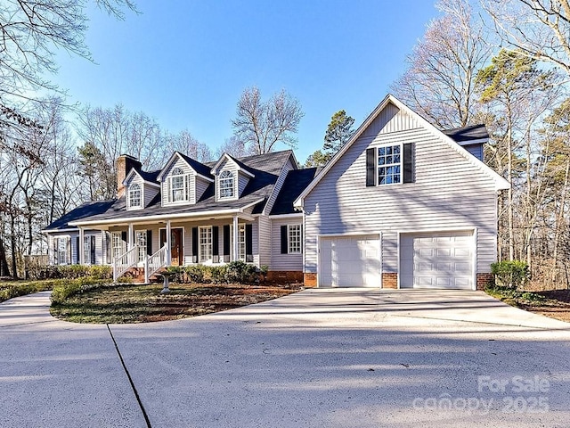 cape cod-style house featuring a garage and a porch