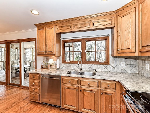 kitchen with sink, crown molding, light hardwood / wood-style flooring, appliances with stainless steel finishes, and light stone counters