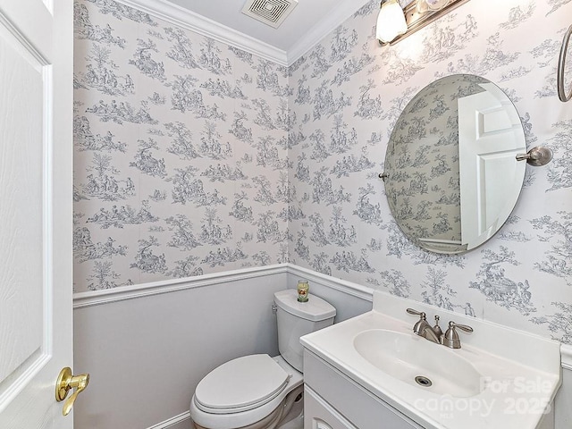 bathroom with ornamental molding, vanity, and toilet