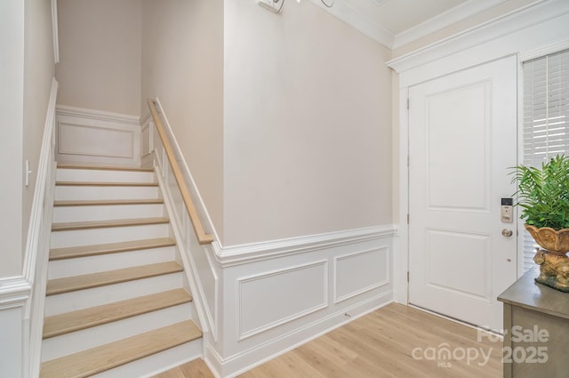 staircase with hardwood / wood-style flooring and crown molding