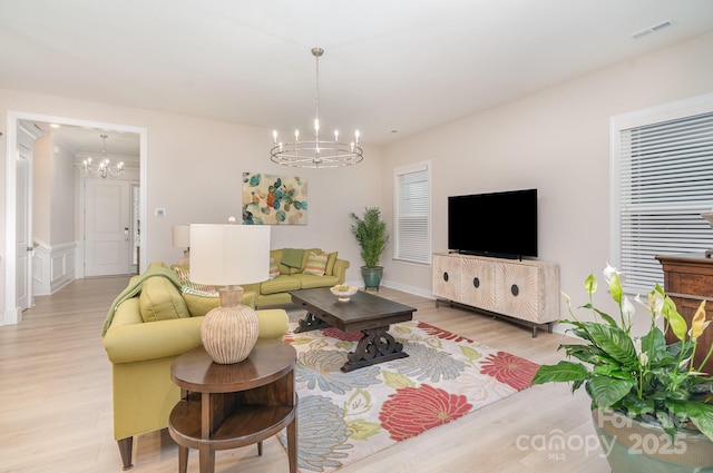 living room with light wood-type flooring and a notable chandelier