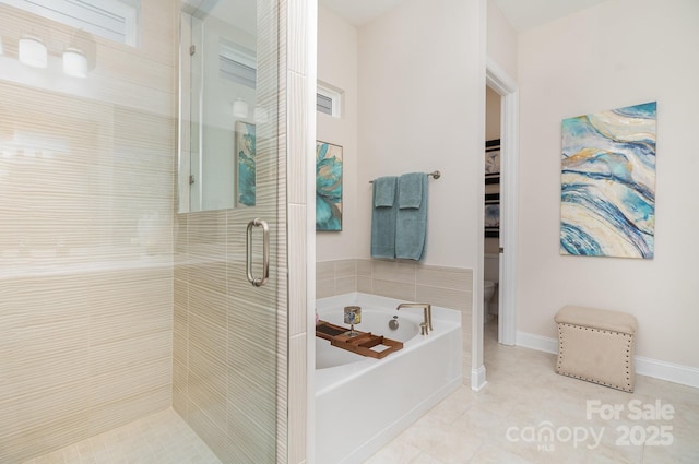 bathroom featuring tile patterned flooring, independent shower and bath, and toilet