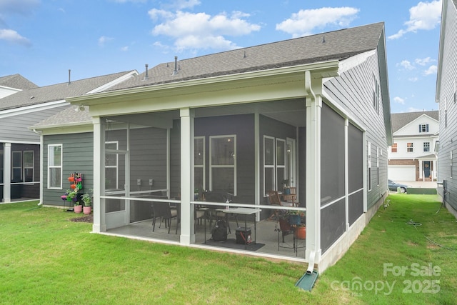 back of property with a patio, a sunroom, and a lawn