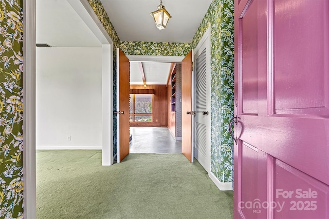 corridor featuring beamed ceiling and carpet flooring