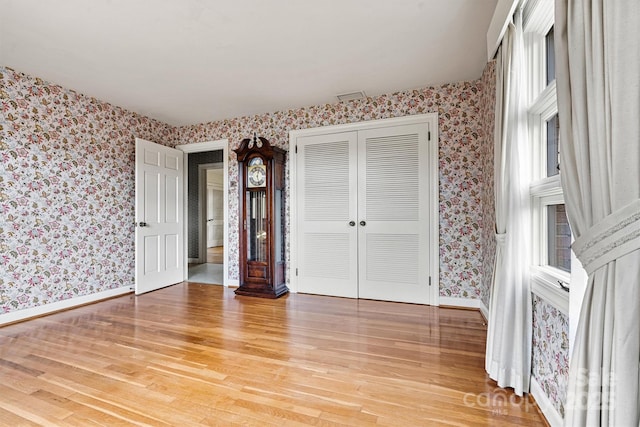 unfurnished bedroom featuring light hardwood / wood-style flooring and a closet