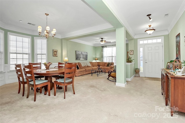 carpeted dining area with a chandelier and crown molding