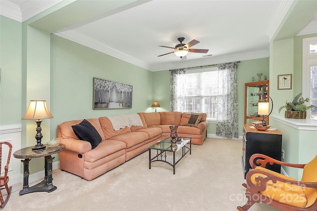 living room with ceiling fan, ornamental molding, and light carpet