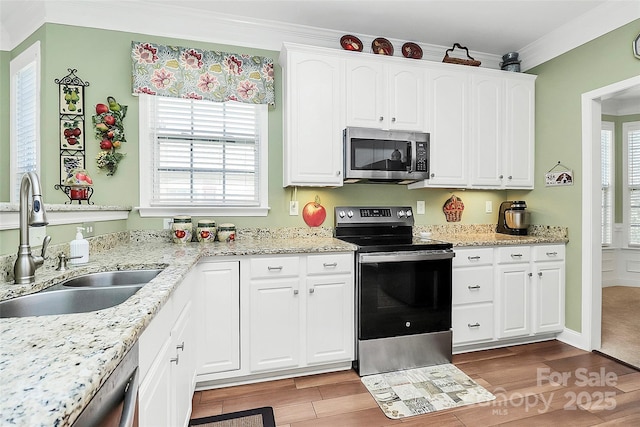 kitchen featuring sink, crown molding, stainless steel appliances, and white cabinets