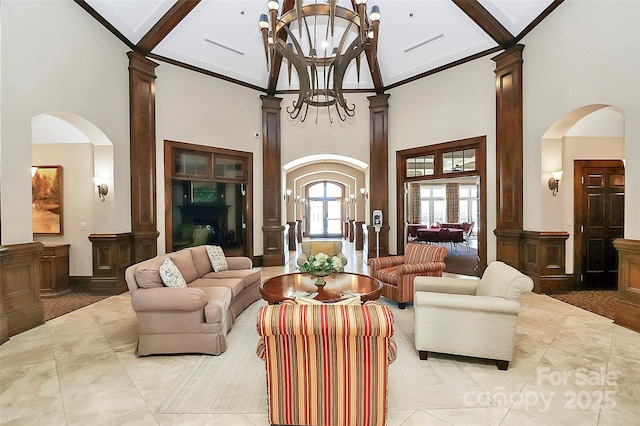 lobby with a high ceiling, ornate columns, beamed ceiling, and an inviting chandelier