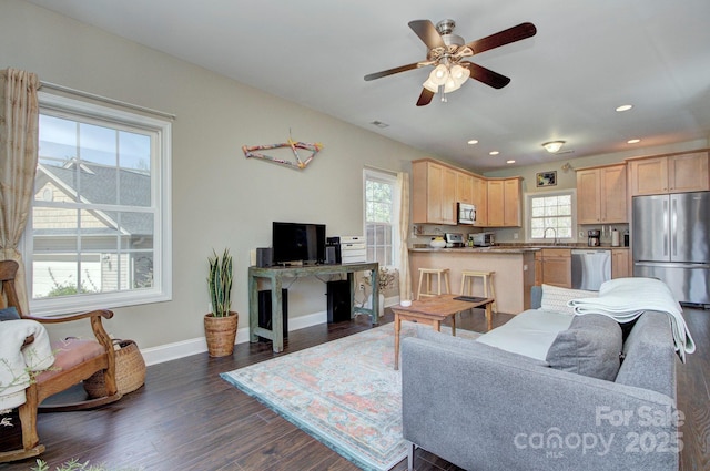 living room featuring dark wood-type flooring, sink, and ceiling fan