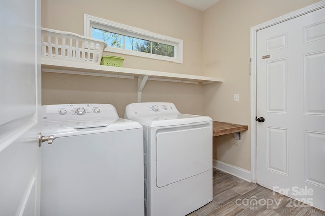 laundry area with hardwood / wood-style floors and washing machine and clothes dryer