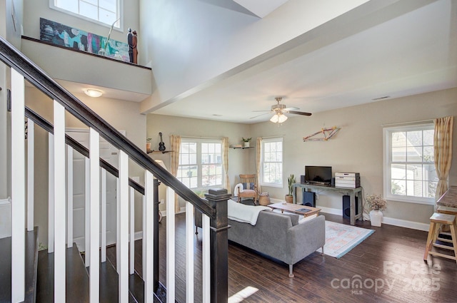 living room featuring a high ceiling, ceiling fan, and dark hardwood / wood-style flooring