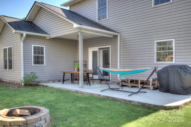 back of house featuring a fire pit, a lawn, and a patio