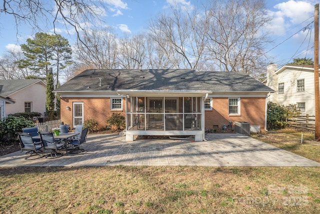 rear view of house with cooling unit, a patio, a yard, and a sunroom