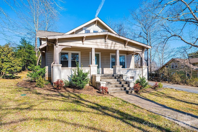 bungalow-style house with covered porch and a front lawn