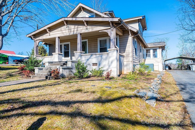 bungalow-style house with a front yard and covered porch