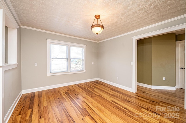 spare room featuring wood-type flooring, a textured ceiling, and crown molding