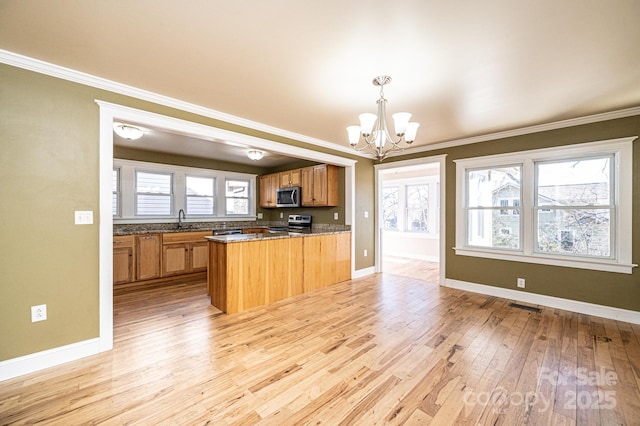 kitchen featuring appliances with stainless steel finishes, decorative light fixtures, a chandelier, light hardwood / wood-style floors, and kitchen peninsula