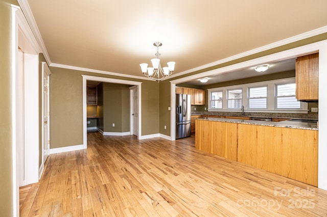 kitchen featuring an inviting chandelier, stainless steel refrigerator with ice dispenser, ornamental molding, light hardwood / wood-style floors, and kitchen peninsula