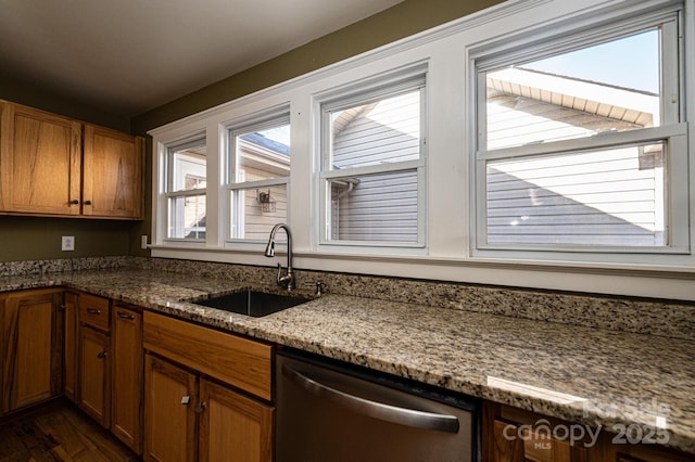 kitchen with stone counters, dishwasher, sink, and dark hardwood / wood-style floors