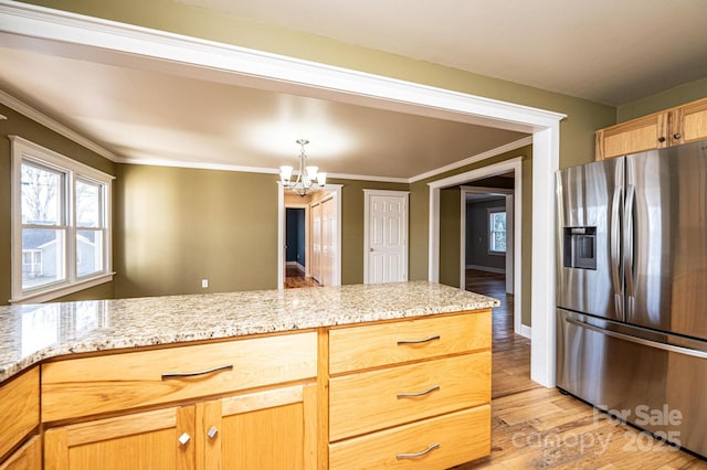 kitchen featuring stainless steel fridge, a chandelier, light stone counters, crown molding, and light wood-type flooring