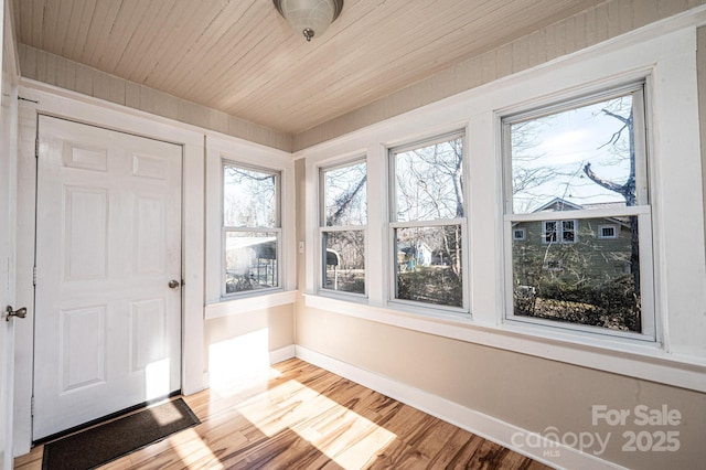 unfurnished sunroom with wood ceiling