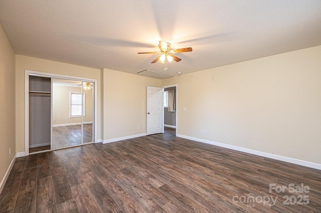 unfurnished bedroom featuring a closet, a textured ceiling, dark hardwood / wood-style floors, and ceiling fan