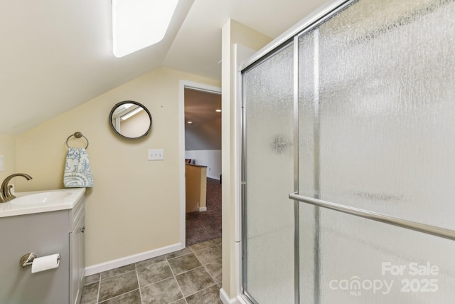 bathroom with lofted ceiling, vanity, tile patterned flooring, and a shower with door