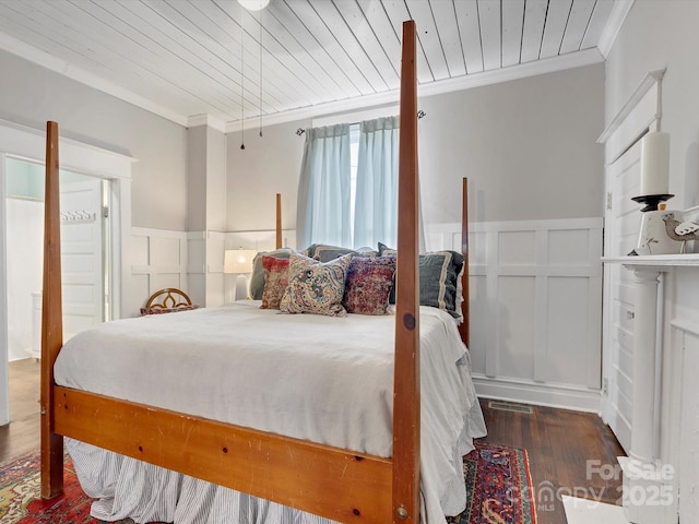 bedroom featuring wainscoting, wood finished floors, wood ceiling, and crown molding