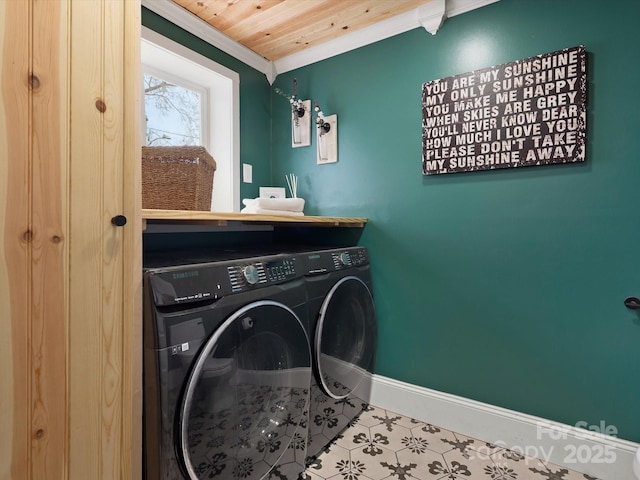 laundry area featuring laundry area, wooden ceiling, washing machine and clothes dryer, and baseboards