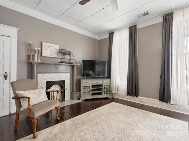 living area with a ceiling fan, visible vents, a wealth of natural light, and wood finished floors