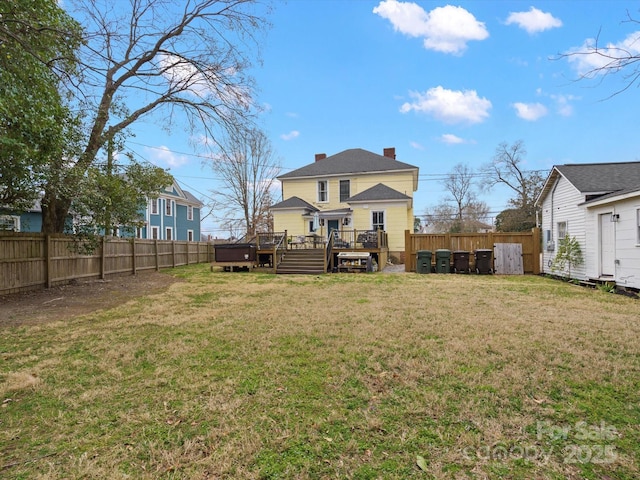 back of property featuring a yard, a chimney, a fenced backyard, and a wooden deck