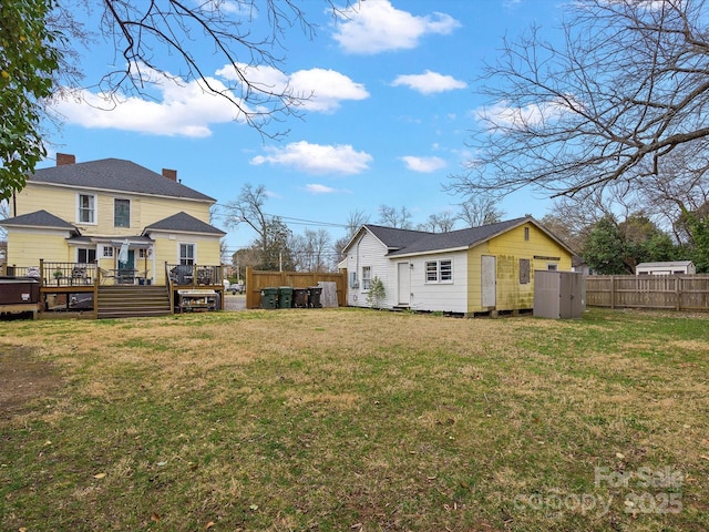 exterior space featuring a yard, fence, and a wooden deck