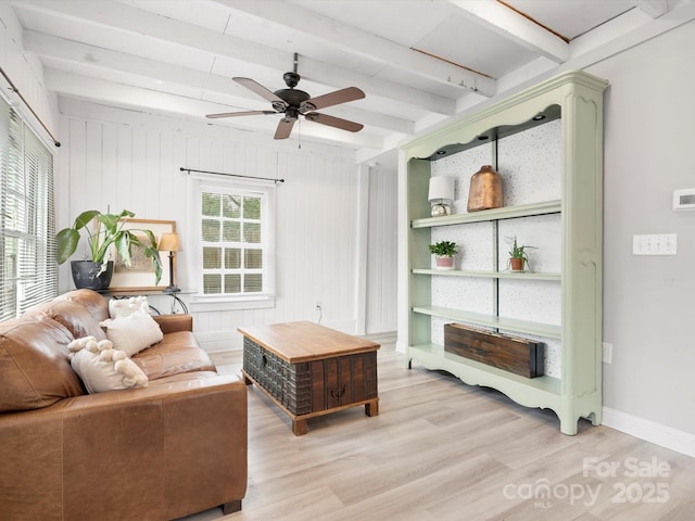 living room with light wood finished floors, ceiling fan, baseboards, and beamed ceiling