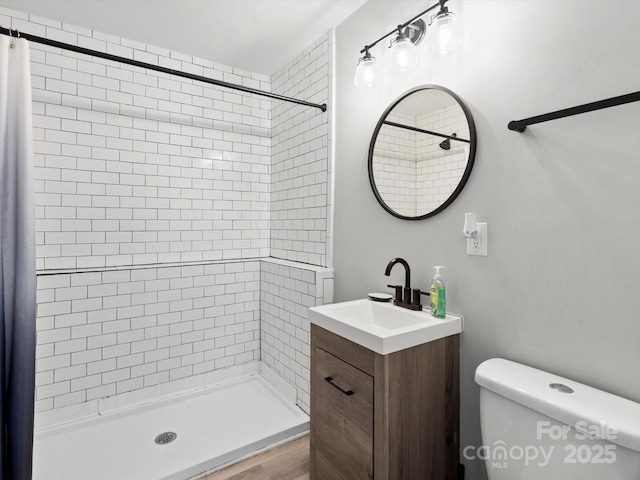 full bathroom with a stall shower, vanity, and toilet