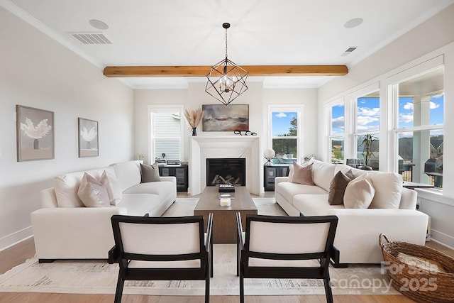 living room with beamed ceiling, a notable chandelier, and light hardwood / wood-style flooring