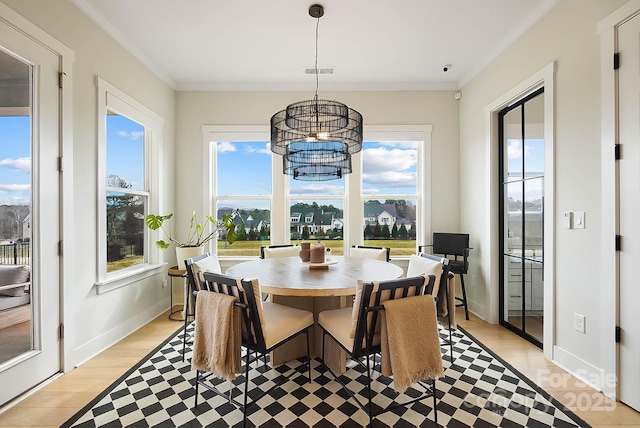 dining room featuring crown molding and light hardwood / wood-style flooring