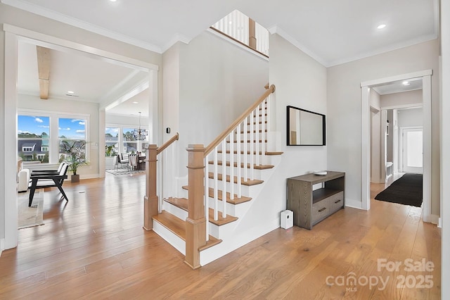 staircase featuring wood-type flooring and ornamental molding